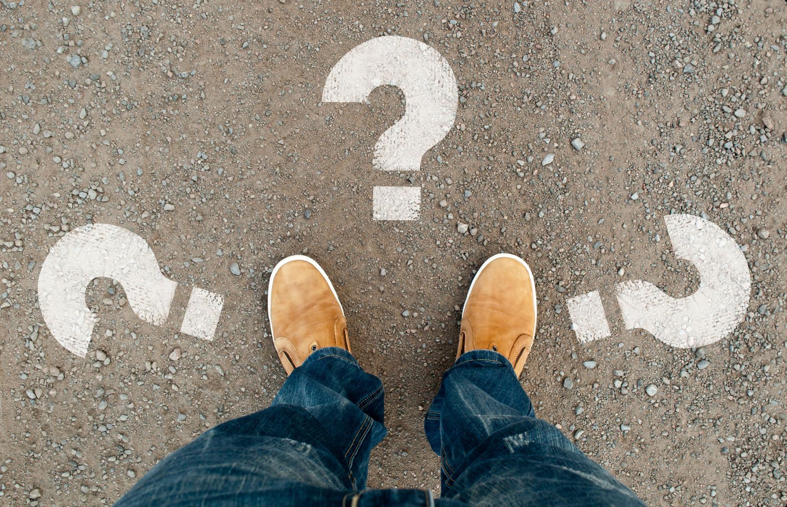 Person standing at a crossroads of question marks, choosing a direction